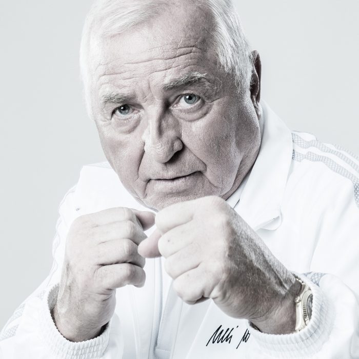 Ulli Wegner, Boxtrainer in weißem Trainingsanzug in einer Boxpose